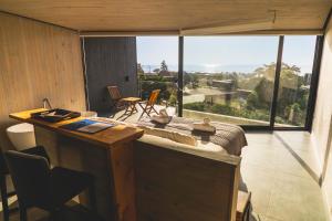 皮奇勒姆德默什披市勒亩山林小屋的客房设有大窗户和一张美景办公桌。