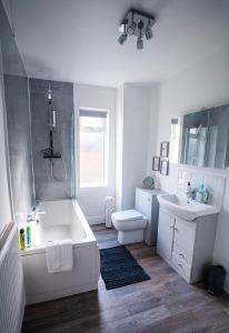 纽尼顿Comfortable equipped House in Nuneaton sleeps5 with FREE parking的带浴缸、盥洗盆和卫生间的浴室