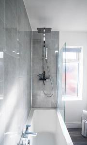 纽尼顿Comfortable equipped House in Nuneaton sleeps5 with FREE parking的带淋浴和浴缸的浴室