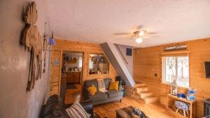 达克科里克村Charming Blue Farmhouse Cabin的带沙发和吊扇的客厅