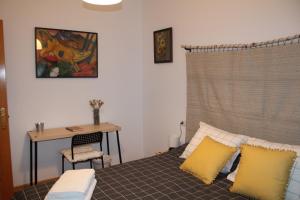 莱昂La casa de los abedules的一间卧室配有书桌和一张带黄色枕头的床。