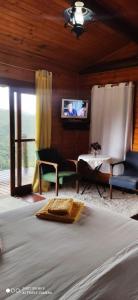 维奥康德马奥Cabana Vista Maravilhosa的一间卧室配有一张床、一张沙发和一张桌子