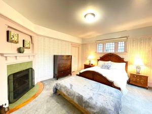 维多利亚Parlor Suite in Heritage Manor, Fairfield, near DT的一间卧室设有一张大床和一个壁炉