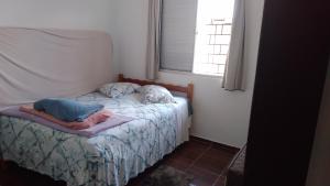 瓜拉图巴Brisa do Mar Guaratuba的窗户客房内的小床