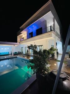 萨利波图尔VILLA NAYFAL的一座在晚上设有游泳池的大房子