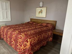 罗斯米德Plaza Inn Motel - Los Angeles area的一间卧室配有一张红色棉被的床