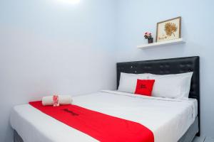 三宝垄RedDoorz near Puri Anjasmoro Area Semarang的一间卧室配有一张床铺,床上铺有红色毯子
