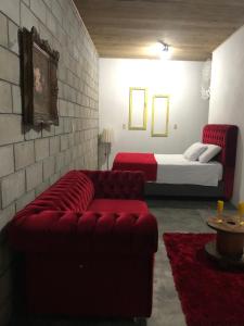普腊亚罗萨Pousada Rosa Bonita的客厅配有沙发和1张床