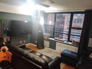 OssiningLovely one bedroom apartment in Westchester, NY!的客厅配有真皮沙发和电视