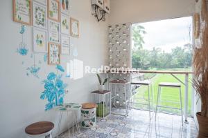 日惹Twin House near UII Yogyakarta Mitra RedDoorz的一间设有白色墙壁、窗户和桌子的房间