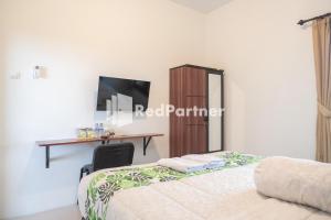 日惹Twin House near UII Yogyakarta Mitra RedDoorz的一间卧室配有两张床、一张桌子和一张桌子