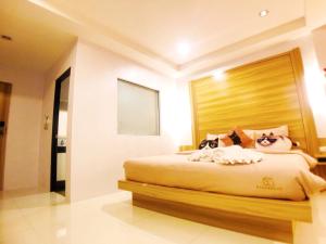 芭东海滩猫舍酒店的一间卧室配有一张大床和木制床头板