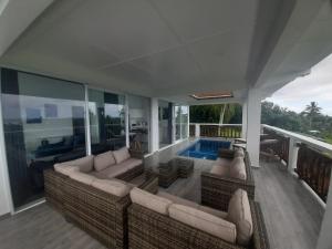 阿瓦鲁阿Mai'i Villa 1 - Muri的带沙发的客厅和游泳池