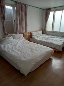 仁川市Jemulpo house - Foreigner Only的配有窗户的客房内的两张床