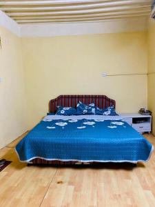 阿尔哈姆拉Sehma Guest House的一间卧室配有一张带蓝色棉被的床