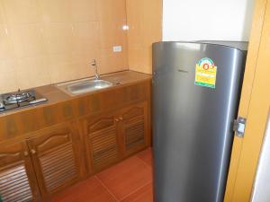 清迈P and A Thai Lanna Resort的厨房里配有不锈钢冰箱,设有水槽