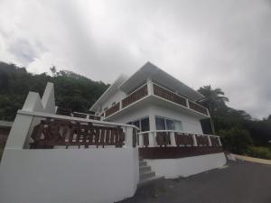 阿瓦鲁阿Mai'i Villa 2 - Muri的带阳台的白色房屋和棕榈树
