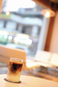 全州市Jeonju Hanok Taejogung Hotel的坐在桌子上喝杯咖啡