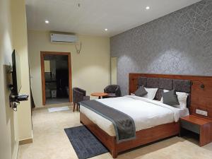 迪布鲁加尔HOTEL GOLDEN ORCHID的一间带大床的卧室和一间客厅