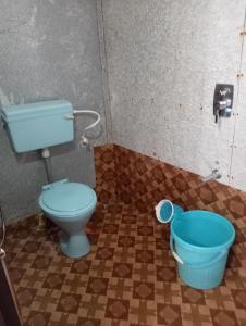 帕特南Namaste Beach Huts的一间带蓝色卫生间和桶的浴室
