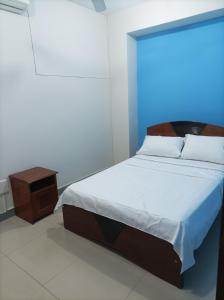 伊基托斯Emmanuel&Cavita的一间卧室配有一张床和一个床头柜