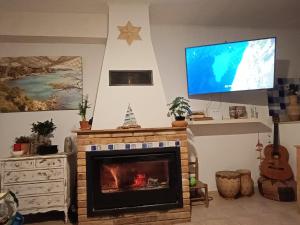 塔拉戈纳Flaire Mar的客厅设有壁炉和平面电视。