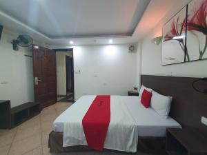 河内Ha Noi Vang Hotel Hoang Ngan的一间卧室配有一张带红白毯子的床
