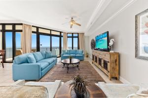 奥兰治比奇The Oasis at Orange Beach 2203的客厅配有蓝色的沙发和电视