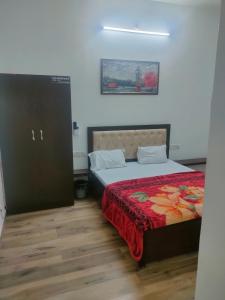阿格拉hotel khubsaras palace by chhabra's的一间卧室配有一张带红色毯子的床