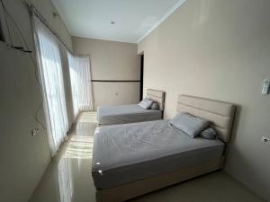 DemanganGuest House DiFi Timoho的一间卧室设有两张床和窗户。