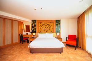 芭堤雅市中心Centara Nova Hotel Pattaya的一间卧室配有一张床和两张红色椅子