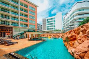 芭堤雅市中心Centara Nova Hotel Pattaya的一座建筑物中央的游泳池