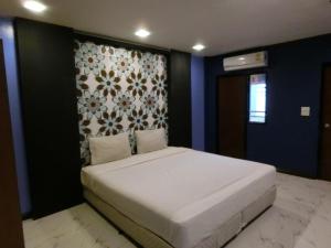 Ban KoNewYork Suite Hotel的卧室配有一张白色大床和墙壁