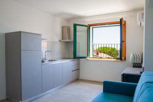 托尔托雷托Residence Playa的厨房配有蓝色的沙发和窗户。