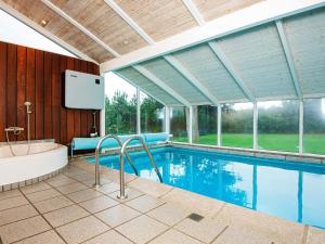 Nørager10 person holiday home in Alling bro的一座大型游泳池,配有浴缸和一台电视