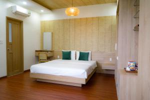 岘港Bambu Hotel的卧室配有一张白色大床