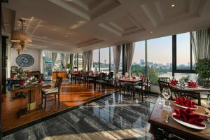 河内San Grand Hotel & Spa的用餐室配有桌椅和大窗户