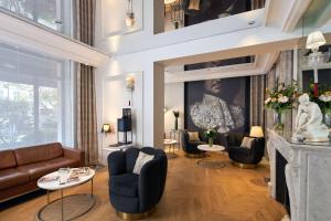 巴黎Hôtel Tourisme Avenue的客厅配有沙发、椅子和壁炉
