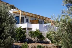 圣加利尼Vrachos Luxury Home 2的山丘上树木林立的房屋