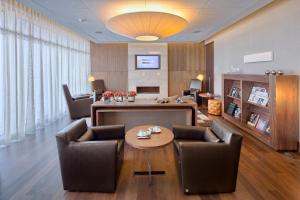 里斯本里斯本史诗萨纳酒店的客厅配有椅子和桌子。