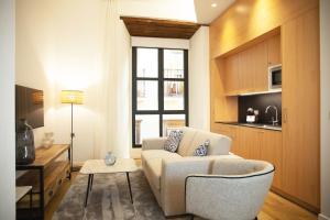塞维利亚nQn Aparts & Suites Sevilla的客厅配有沙发和桌子
