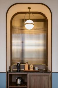 乌隆他尼Hotel MOCO的厨房配有镜子和桌子及锅碗瓢盆