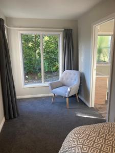 玛普瓦Private Guest House的一间卧室配有蓝色椅子和窗户