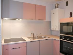 拉蒙维尔圣阿尼Appartement Le Céleste 113 - deux chambres的厨房配有粉色橱柜、水槽和微波炉