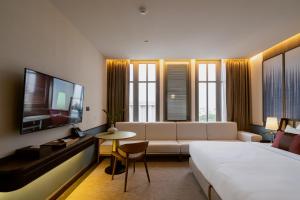 乌隆他尼Hotel MOCO的酒店客房配有床、沙发和电视。