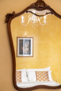 威尼斯圣卢卡宫住宿加早餐旅馆的床上方的镜子,上面有一张儿童的照片