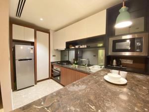 吉隆坡Anggun Residence Modern Suites with Netflix 3Mins to Monorail KL Near KLCC的厨房配有带水槽和冰箱的台面