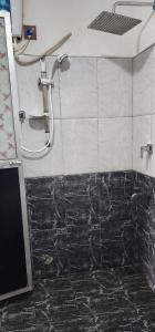 拉特纳普勒Green Leaf Holiday Bungalow的浴室铺有黑白瓷砖,设有淋浴。