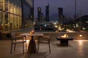 蒙特雷Hyatt Place Monterrey Valle的市景阳台的桌椅