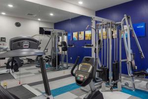 凯夫城山洞城康福特茵酒店&套房的一间拥有蓝色墙壁和跑步机的健身房